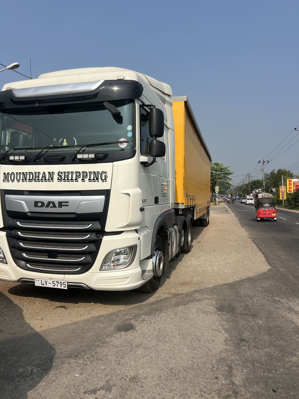 Moundhan Shipping DAF prime mover with a yellow curtain-side trailer on the road